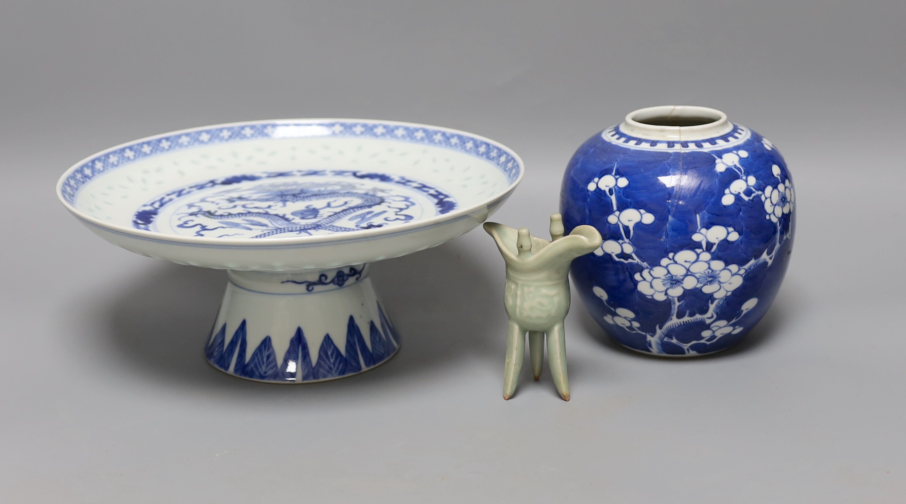 A Chinese blue and white “dragon“ footed dish, 25 cm diameter a Chinese blue and white prunus jar and a celadon glazed small vessel (3)